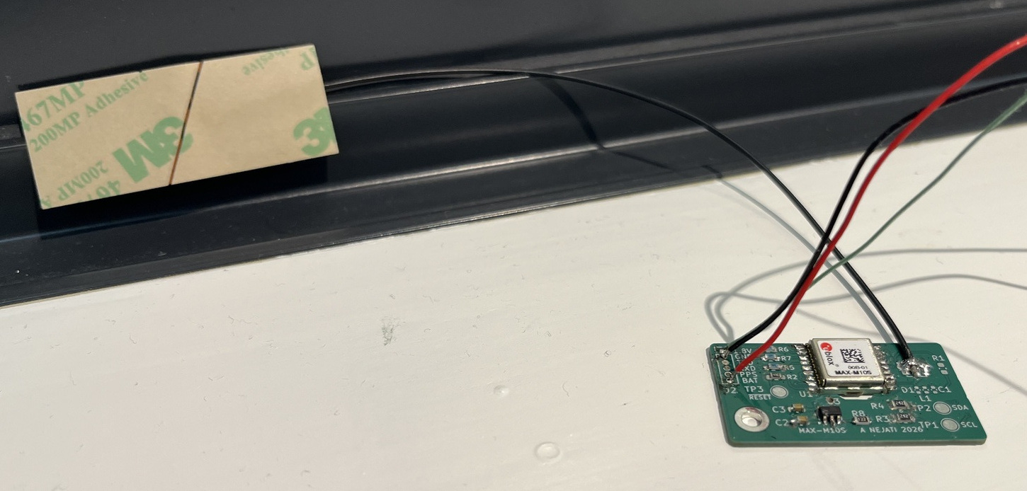 GNSS module with power/UART wires soldered and the coax antenna attached directly to the board.